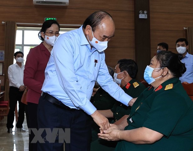 Chủ tịch nước Nguyễn Xuân Phúc thăm hỏi thương bệnh binh tại Trung tâm nuôi dưỡng bệnh binh nặng và Điều dưỡng người có công tỉnh Hà Nam, ngày 23.7.2021 - Ảnh: TTXVN