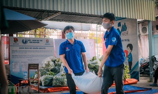 Thanh niên tình nguyện vận chuyển gạo, lương thực cho những hộ dân thuộc khu vực phong tỏa trên địa bàn quận Tân Phú. Ảnh: TTXVN