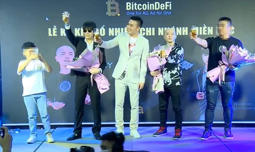 Phạm Tuấn (thứ 2 từ trái qua), Nguyễn Tiến Chiến (ở giữa) và Mai Thế Tùng (thứ 2 từ phải qua) tại sự kiện của Bitcoin Defi diễn ra tại Bắc Ninh, ngày 5.7. Sự kiện này đã không đảm bảo quy định chống dịch dù có khoảng 100 người tham dự. Ảnh: Căt từ clip.