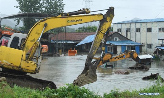 Nhân viên cứu hộ đắp đất và đá ở Từ Hi, Ninh Ba, tỉnh Chiết Giang hôm 26.7 khi bão In-fa đổ bộ. Ảnh: Tân Hoa Xã