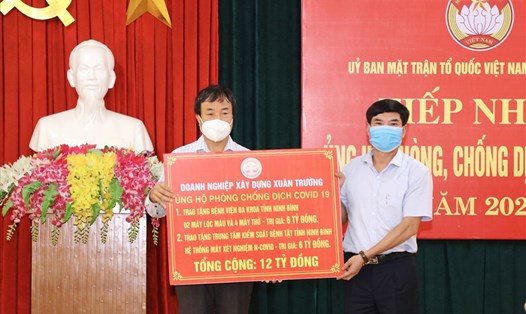 Ông Nguyễn Văn Trường, Giám đốc DN Xây dựng Xuân Trường (bên trái) trao tặng các thiết bị, dụng cụ y tế ủng hộ phòng chống dịch COVID-19. Ảnh: NT