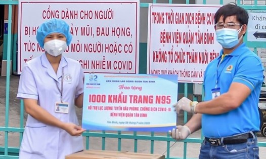 Ông Đinh Trần Thanh Tâm, Chủ tịch LĐLĐ quận Tân Bình, trao tặng 1.000 khẩu trang N95 hỗ trợ các nhân viên y tế Bệnh viện Tân Bình chống dịch. Ảnh: Đức Long