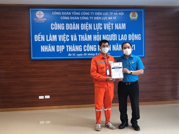 Cán bộ Công đoàn tặng quà người lao động (bên trái) có hoàn cảnh khó khăn. Ảnh: CĐĐL