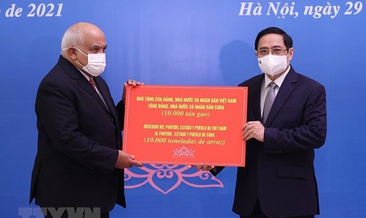 Thủ tướng Phạm Minh Chính trao tượng trưng món quà 10.000 tấn gạo Việt Nam tặng Cuba. Ảnh: TTXVN