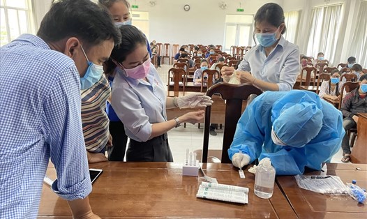 Cán bộ Trung tâm Kiểm soát Bệnh tật tỉnh Khánh Hoà đang hướng dẫn đội ngũ làm y tế tại các doanh nghiệp thực hiện test nhanh COVID-19. Ảnh: Thanh Nhàn
