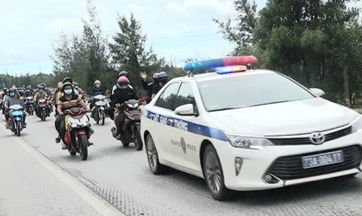 Lực lượng CSGT - CA tỉnh Quảng Bình dùng xe chuyên dụng dẫn đường cho người dân đi xe máy tự phát về quê khi đi ngang qua địa bàn. Ảnh: CTV