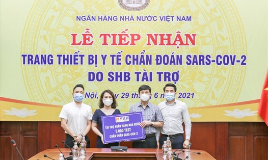 Bà Ninh Thị Lan Phương – Phó Tổng Giám đốc đại diện Ngân hàng SHB trao tặng NHNN 5.000 kit xét nghiệm nhanh COVID-19. Ảnh: SHB