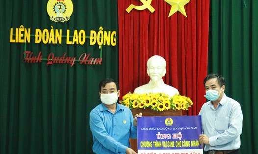 Ông Phan Xuân Quang (trái) trao hơn 1,2 tỉ đồng đến đại diện Quỹ Tấm lòng Vàng Lao Động để ủng hộ chương trình vaccine cho công nhân. Ảnh: Thái Bình