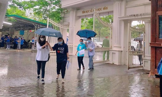 Thí sinh tại điểm thi Trường THPT chuyên Đại học Vinh gặp nhiều khó khăn trong điều kiện thời tiết mưa lớn. Ảnh: Quang Đại