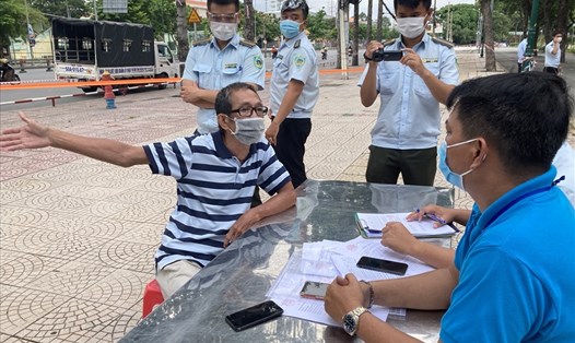 Một người dân ở  Quận Phú Nhuận, TPHCM bị xử phạt vì không đeo khẩu trang đúng quy định tại nơi công cộng sáng 9.7.2021. Ảnh Anh Tú