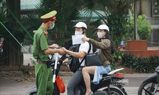 Lực lượng chức năng kiểm tra giấy đi đường của người dân trong những ngày thành phố Hà Nội thực hiện giãn cách. Ảnh chụp sáng 9.8: Tùng Giang