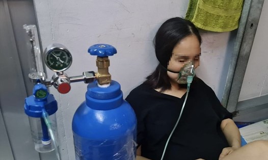 Người nhà anh Lâm Quang Trường thở oxy tại nhà trong lúc chờ được nhập viện. Ảnh: NVCC