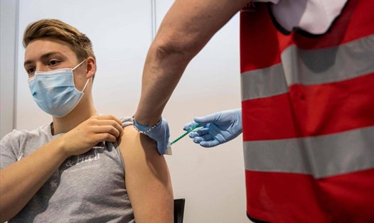 Tiêm vaccine COVID-19 và thực hiện các biện pháp truyền thống khác là cách hiệu quả để ngăn chặn biến thể Delta. Ảnh: AFP