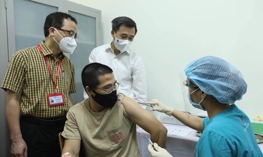GS.TS Tạ Thành Văn và GS.TS Trần Văn Thuấn chứng kiến mũi tiêm thử nghiệm cho tình nguyện viên đầu tiên. Ảnh: Bộ Y tế