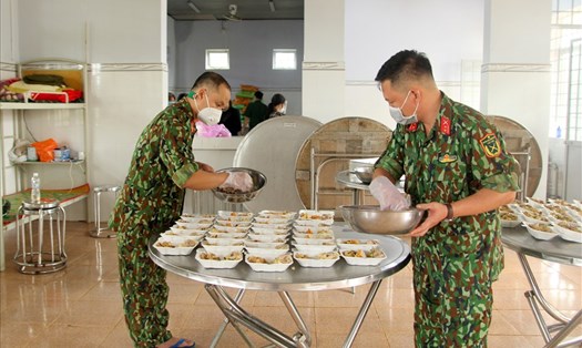 Các cán bộ chiến sỹ Ban Chỉ huy Quân sự huyện Đắk R'lấp chuẩn bị bữa cơm cho người dân đang cách ly. Ảnh: Phan Tuấn