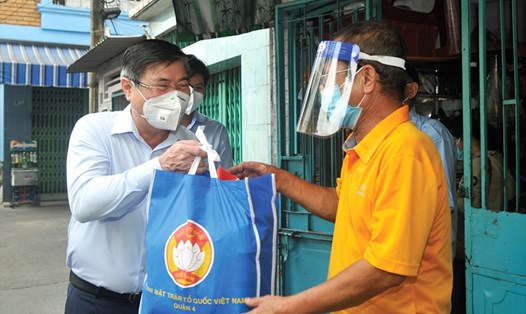 Chủ tịch UBND TPHCM Nguyễn Thành Phong (trái) tặng túi quà cho người dân khó khăn vì dịch COVID-19. Ảnh: Cao Thăng