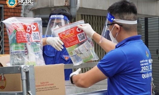 Trao túi thuốc an sinh cho F0 cách ly tại nhà trên địa bàn phường 1, quận Tân Bình (TPHCM). Ảnh: HCDC
