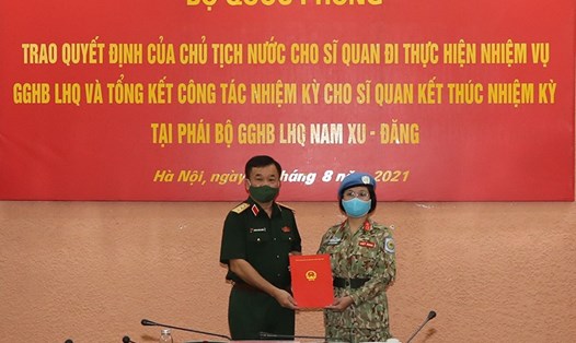 Thừa ủy quyền của Chủ tịch nước, Thượng tướng Hoàng Xuân Chiến trao quyết định cho Trung tá Vũ Thị Kim Oanh đi làm nhiệm vụ. Ảnh: BQP
