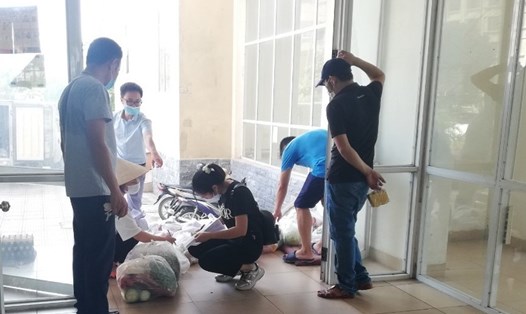 Công nhân thuê trọ tại chung cư CT1A (thôn Bầu, xã Kim Chung, huyện Đông Anh, Hà Nội) nhận thực phẩm mua hộ tại tầng 1 sáng 17.8. Ảnh: Bảo Hân