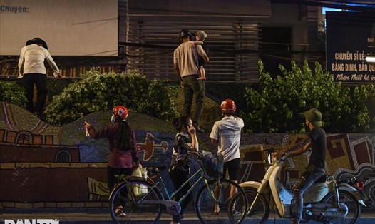 Người dân vượt rào thép gai vận chuyển đồ, rời khỏi khu cách ly ở Hà Nội. Ảnh: Tố Linh/Dân trí