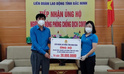 Bà Nguyễn Thị Vân Hà - Chủ tịch LĐLĐ tỉnh Bắc Ninh tiếp nhận ủng hộ của LĐLĐ tỉnh Ninh Bình. Ảnh: CĐBN