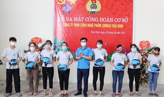Chủ tịch Liên đoàn Lao động tỉnh Thái Bình - Bùi Xuân Vinh tặng mũ bảo hiểm cho những đoàn viên mới gia nhập tổ chức công đoàn Việt Nam. Ảnh: B.M