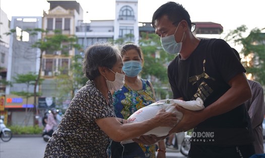 Phát gạo, khẩu trang miễn phí cho người khó khăn vì dịch COVID-19 tại Hà Nội. Ảnh: Tùng Giang