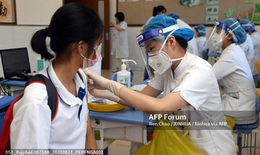 Nhân viên y tế tiêm vaccine COVID-19 cho một nữ sinh ở Bắc Kinh, Trung Quốc vào ngày 21.8.2021. Ảnh: AFP