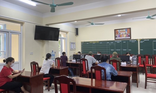 Giáo viên trường THCS Hoàng Hoa Thám (Ba Đình, Hà Nội) hỗ trợ phụ huynh trong ngày đăng kí tuyển sinh đầu cấp trực tuyến cho năm học mới. Ảnh: NTCC