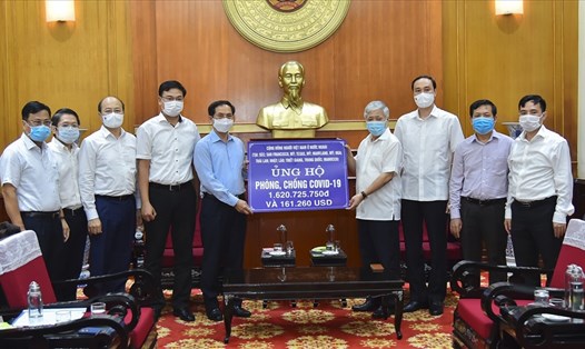 Bộ trưởng Bộ Ngoại giao Bùi Thanh Sơn trao tượng trưng số tiền của cộng đồng người Việt Nam ở nước ngoài ủng hộ Quỹ vaccine phòng, chống COVID-19. Ảnh VGP