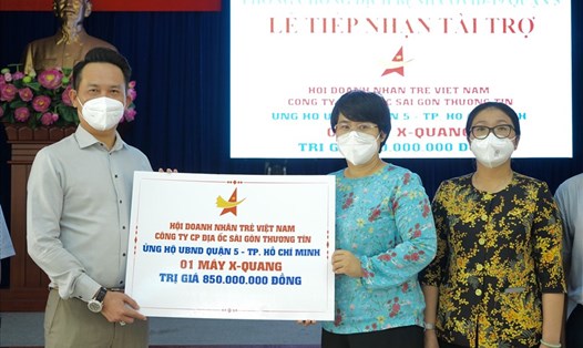 Ông Đặng Hồng Anh - Chủ tịch Hội Doanh nghiệp Trẻ Việt Nam, Phó Chủ tịch Tập đoàn TTC - trao tặng máy X-Quang di động đến bà Trương Minh Kiều - Chủ tịch UBND Quận 5, TPHCM.