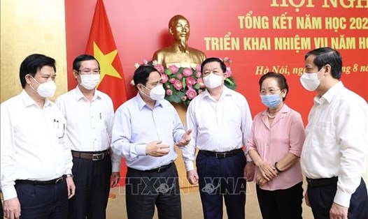Thủ tướng Chính phủ Phạm Minh Chính trao đổi với các địa biểu bên lề hội nghị tổng kết năm học 2020-2021. Ảnh: TTXVN