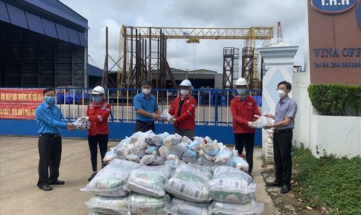 Ông Nguyễn Trường Giang và ông Nguyễn Châu Trinh tặng quà hỗ trợ người lao động tại Công ty TNHH KT Cơ khí Hàng hải Vina Offshore. Ảnh: LĐLĐT