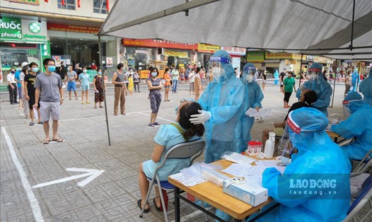 Cán bộ y tế lấy mẫu xét nghiệm COVID-19 ở Hà Nội. Ảnh: Lao Động