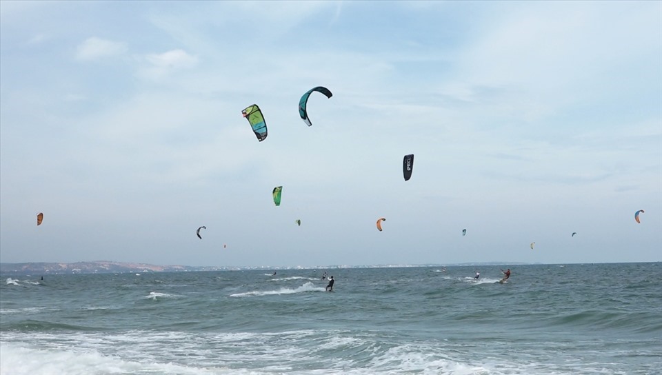 Du khách lướt ván diều trên biển. Ảnh: Phạm Duy