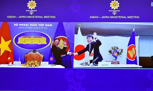 Bộ trưởng Ngoại giao Việt Nam và Nhật Bản bắt tay qua màn hình để chuyển giao vai trò điều phối quan hệ ASEAN - Nhật Bản. Ảnh: BNG