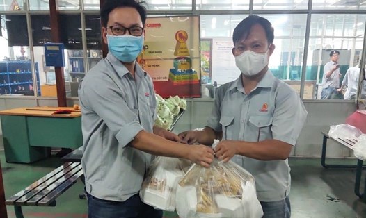 Cán bộ Công đoàn ngành Hoá chất (bên trái) trao hỗ trợ thực phẩm cho người lao động đang thực hiện "3 tại chỗ". Ảnh: CĐHC