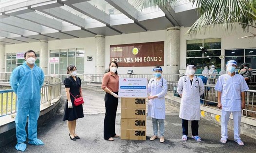 Đại diện Bộ KHĐT trao khẩu trang y tế cho y bác sĩ bệnh viện Nhi Đồng 2-TPHCM. Ảnh: H.L