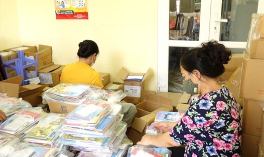 Giáo viên trường THCS Nguyễn Công Trứ (Ba Đình, Hà Nội) đóng gói sách giáo khoa để chuyển phát nhanh tới học sinh. Ảnh: Tường Vân