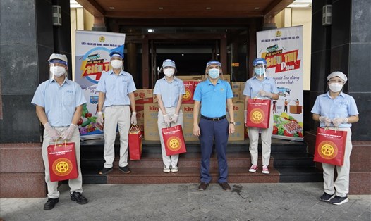 Phó Chủ tịch Liên đoàn Lao động thành phố Hà Nội Lê Đình Hùng (thứ 3 từ phải sang) trao hỗ trợ từ Chương trình "Xe buýt siêu thị 0 đồng" cho công nhân lao động. Ảnh: Hải Anh