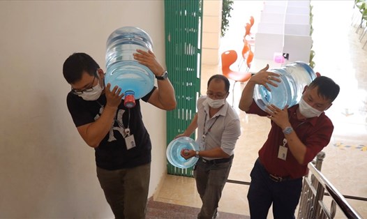 Anh Nguyễn Xuân Tùng - Phó Chủ tịch Công đoàn LG Display (Áo trắng) vận chuyển nước uống đến từng phòng cho công nhân tại khu lưu trú tập trung. Ảnh MD