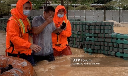 Lực lượng cứu hộ đưa một người dân đến khu vực an toàn ở Hạ Môn, tỉnh Phúc Kiến, phía Đông Nam Trung Quốc, ngày 5/8/2021. Ảnh: AFP