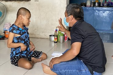 Ông Võ Minh Cường hỗ trợ suất ăn miễn phí cho một người tàn tật trên địa bàn. Ảnh: ML
