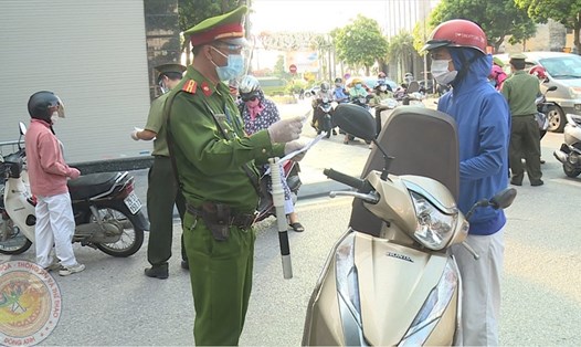 Lực lượng chức năng kiểm tra các trường hợp ra ngoài đường trong khi Hà Nội giãn cách xã hội. Ảnh: CAHN