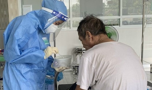 Các y bác sỹ của khu điều trị COVID-19 tại Trung tâm y tế Bàu Bàng, ngoài công việc chuyên môn, còn dọn dẹp vệ sinh, phát cơm nước và kiêm luôn việc chăm sóc người già hàng ngày. Ảnh: TTYT BB