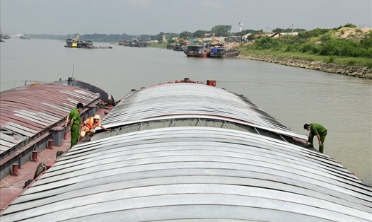 Cảnh sát kiểm tra chiếc tàu biển chở thuê than lậu từ Quảng Ninh đi các tỉnh thành tiêu thụ. Ảnh: Cục CSGT