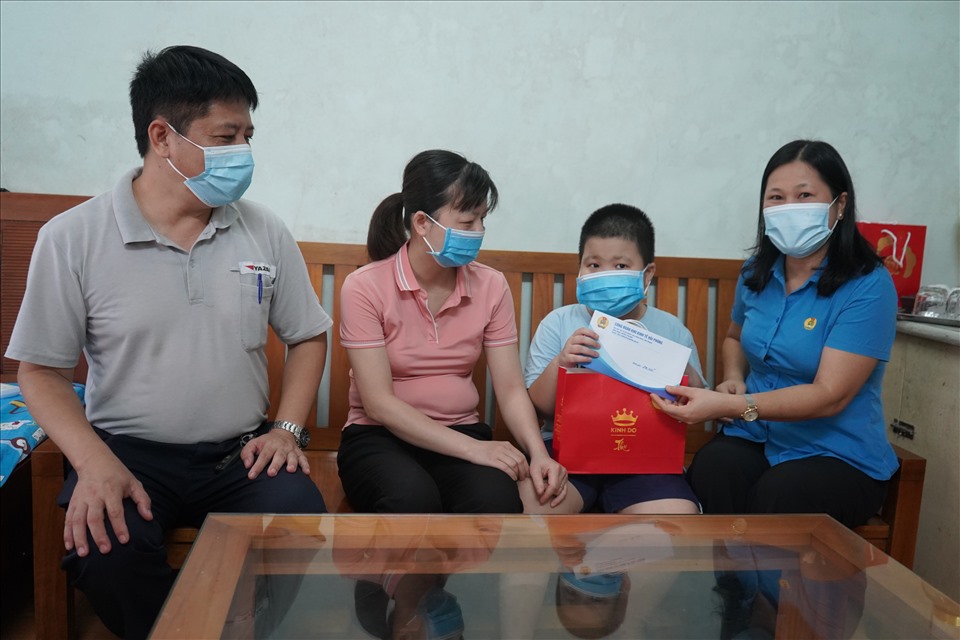 Lãnh đạo Công đoàn Khu kinh tế Hải Phòng tặng quà cháu Đặng Tuấn Minh, con chị Vũ Thị Mai, công nhân Công ty Yazaki Hải Phòng. Ảnh Mai Dung