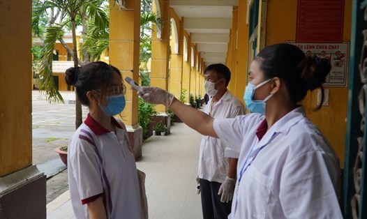 Cán bộ y tế kiểm tra thân nhiệt cho học sinh TPHCM. Ảnh: Chân Phúc