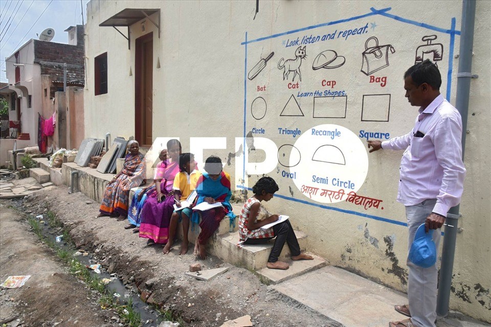 Kalidas Chavdekar, giáo viên trường Aasha Marathi Vidyalay viết lên tường của một ngôi nhà để dạy những học sinh không có điện thoại thông minh để học trực tuyến ở Solapur, thuộc bang Maharashtra, Ấn Độ vào tháng 8.2020. Ảnh minh họa. Ảnh: AFP Kalidas Chavdekar, giáo viên trường Aasha Marathi Vidyalay viết lên tường của một ngôi nhà để dạy những học sinh không có điện thoại thông minh để học trực tuyến ở Solapur, thuộc bang Maharashtra, Ấn Độ vào tháng 8.2020. Ảnh minh họa. Ảnh: AFP