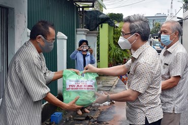 Ông Đặng Minh Thông (phải)  - Bí thư Thành ủy Bà Rịa trao tặng túi an sinh cho người dân.